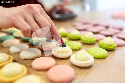 Image of chef decorating macarons shells at pastry shop