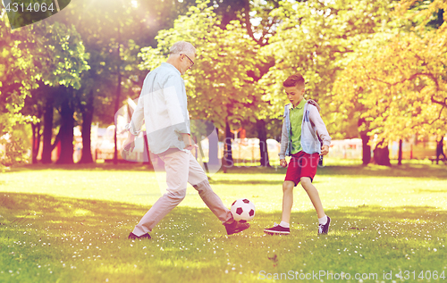 Image of old man and boy playing football at summer park