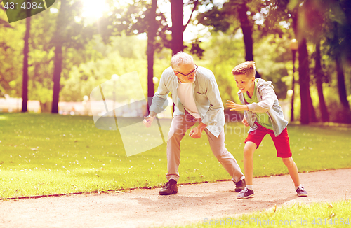 Image of grandfather and grandson racing at summer park