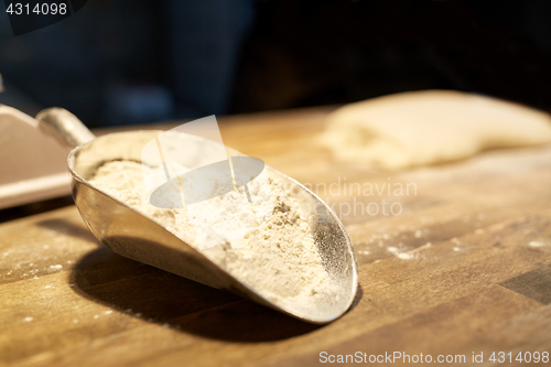 Image of flour in bakery scoop on kitchen table
