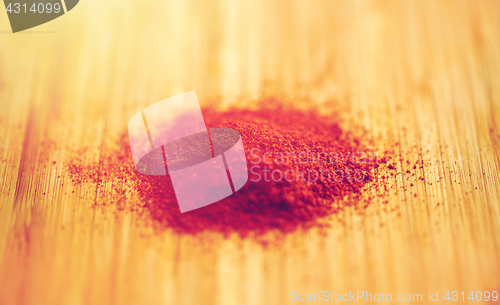 Image of cayenne pepper or paprika powder on wood