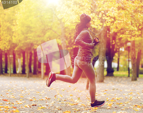 Image of close up of young woman running in autumn park