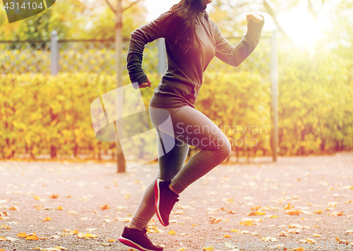 Image of close up of young woman running in autumn park