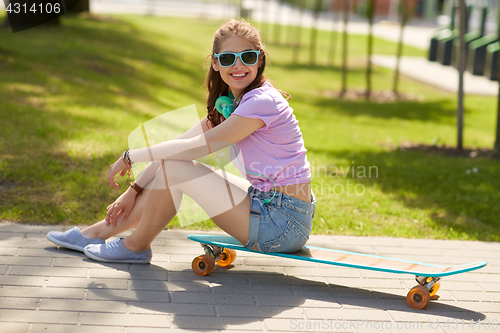 Image of happy teenage girl with headphones and longboard