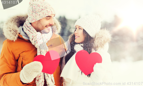 Image of happy couple with red hearts over winter landscape