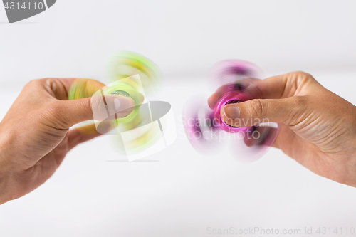 Image of close up of hands playing with fidget spinners