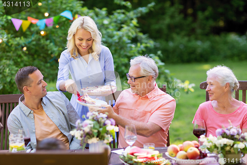 Image of happy family having dinner or summer garden party