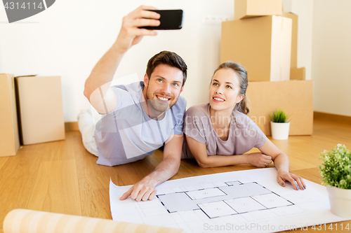 Image of couple with boxes and blueprint moving to new home