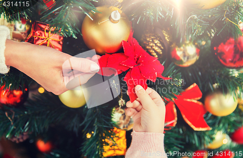 Image of close up of family decorating christmas tree
