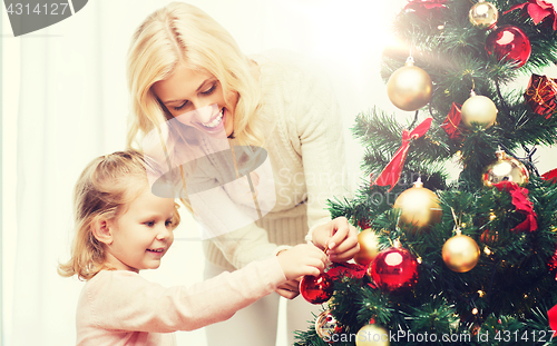 Image of happy family decorating christmas tree at home