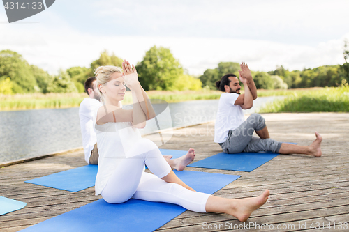 Image of people making yoga and meditating outdoors