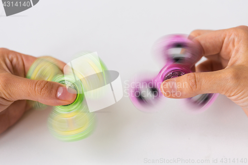 Image of close up of hands playing with fidget spinners