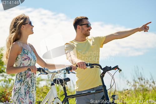 Image of happy young couple with bicycles outdoors