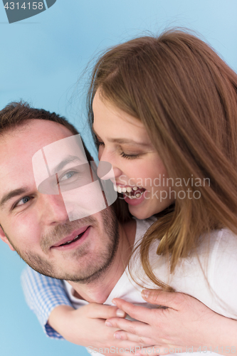 Image of young man piggybacking his girlfriend