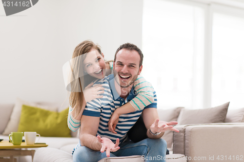 Image of young handsome couple hugging on the sofa