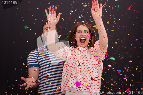 Image of couple blowing confetti in the air isolated over gray