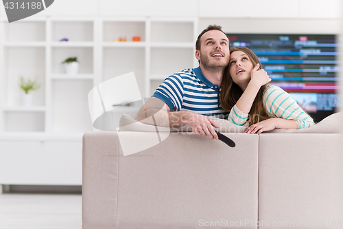 Image of Young couple on the sofa watching television
