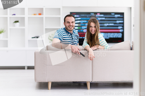 Image of Young couple on the sofa watching television