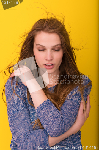 Image of pretty woman playing with her long silky hair