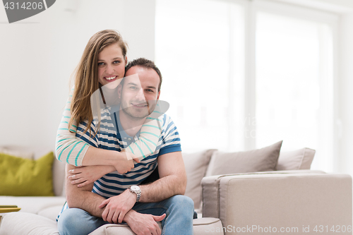 Image of young handsome couple hugging on the sofa