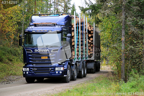 Image of Blue Scania R730 Logging Truck on Autumn Forest Road