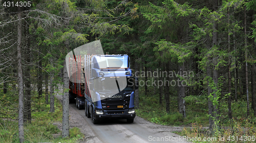 Image of Scania R650 XT Logging Truck Emerges From Forest
