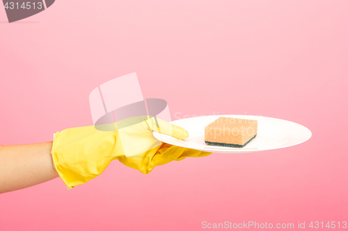 Image of Hands in yellow protective gloves washing a plate