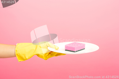 Image of Hands in yellow protective gloves washing a plate