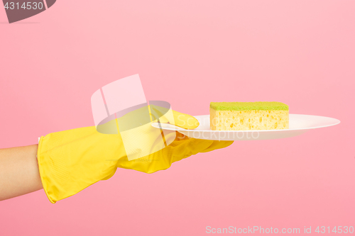 Image of Hands in yellow protective gloves washing a plate