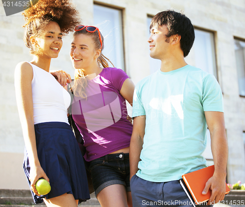 Image of cute group of teenages at the building of university with books huggings, back to school