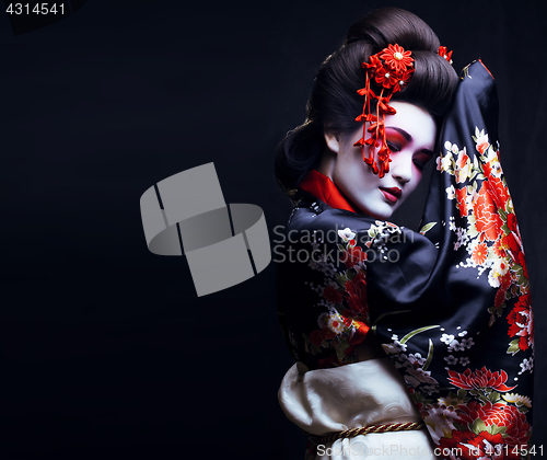 Image of young pretty geisha in kimono with sakura and decoration