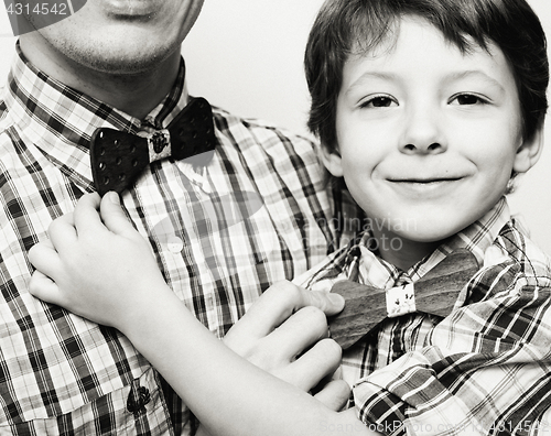 Image of father with son in bowties on white background, casual look family