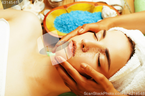 Image of stock photo attractive lady getting spa treatment in salon, close up asian hands on face