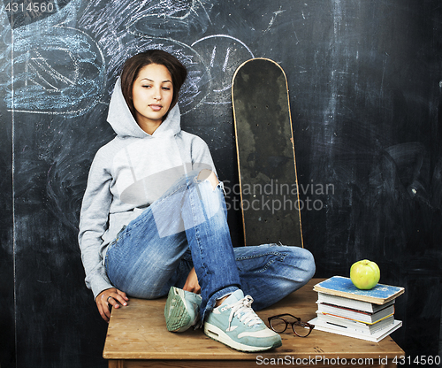 Image of young teenage girl sitting in classroom at blackboard on table, lifestyle education people concept