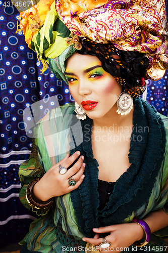 Image of beauty bright woman with creative make up, many shawls on head l