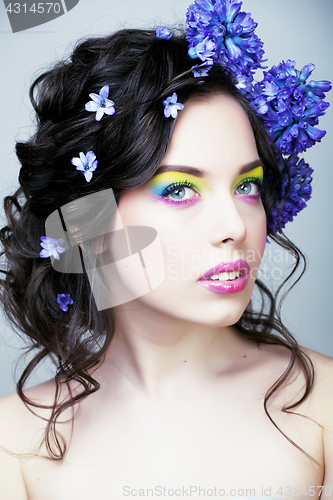 Image of Beauty young woman with flowers and make up close up, real sprin