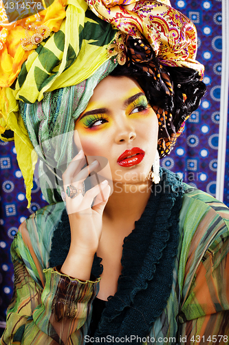 Image of beauty bright woman with creative make up, many shawls on head l