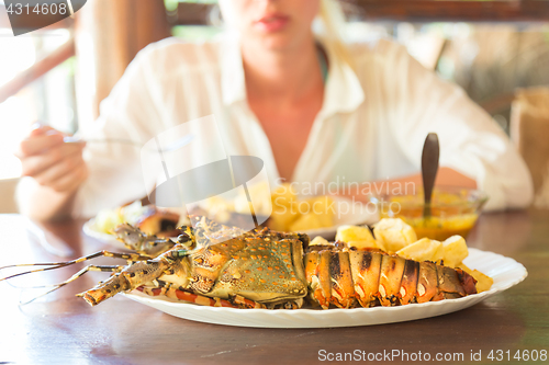 Image of Grilled lobster served with potatoes and coconut sauce.