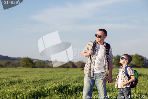 Image of Father and son playing on the field at the day time.