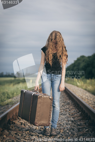 Image of Portrait of young sad ten girl standing with suitcase outdoors a