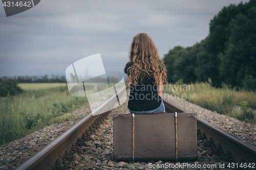 Image of Portrait of young sad ten girl standing with suitcase outdoors a