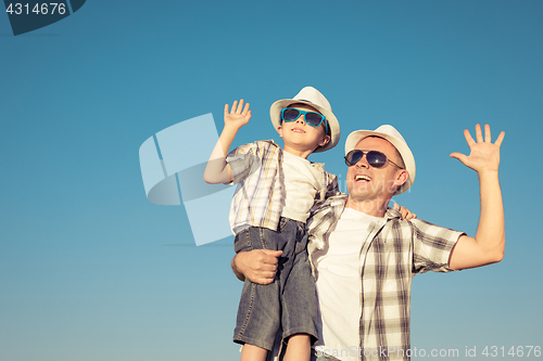 Image of Father and son playing on the field at the day time.