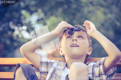 Image of Happy little boy playing in the park at the day time.