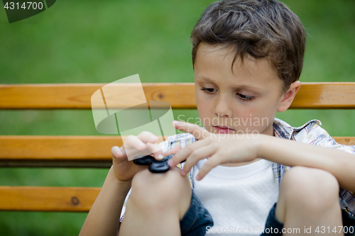 Image of Happy little boy playing in the park at the day time.