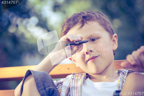 Image of Happy little boy playing in the park at the day time.