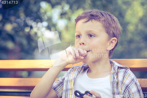 Image of Happy little boy playing in the park at the day time.