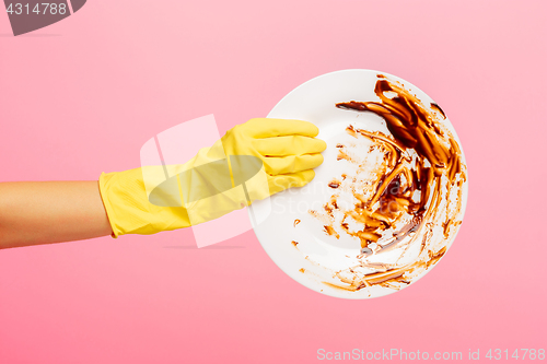 Image of Hands in yellow protective gloves washing a plate