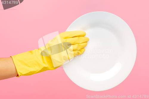 Image of Hands in yellow protective gloves washing a plate