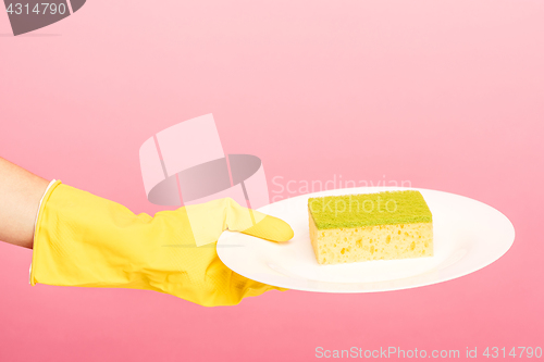 Image of Hands in yellow protective gloves washing a plate