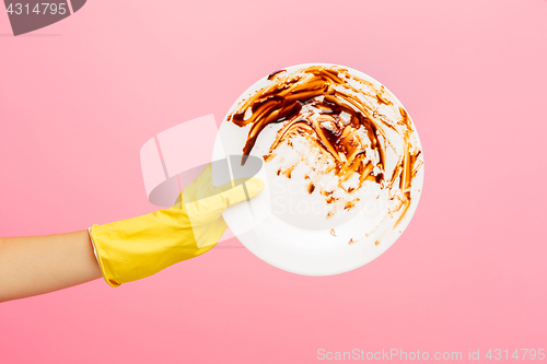 Image of Hands in yellow protective gloves washing a plate